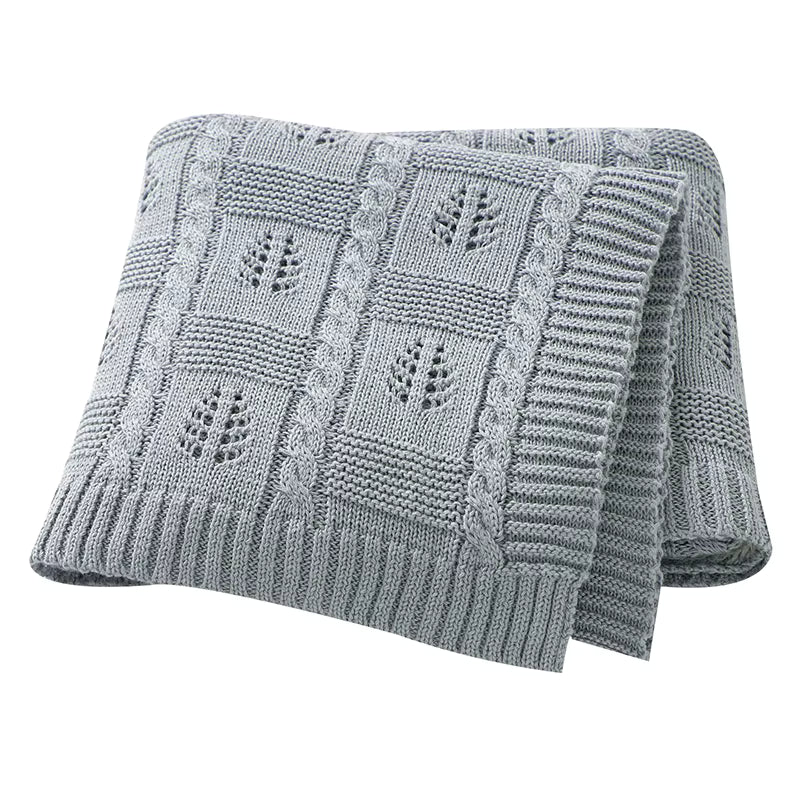 Gray knitted blanket with leaf pattern on a white background