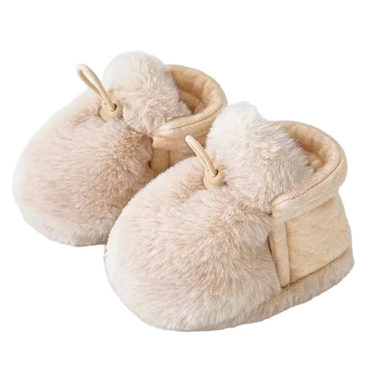 A pair of beige newborn soft fleece crib slippers.