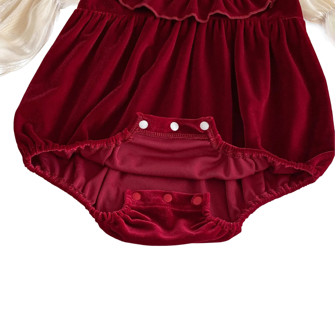 Close-up of the bottom snap closures and soft elastic leg openings on the red velvet baby romper