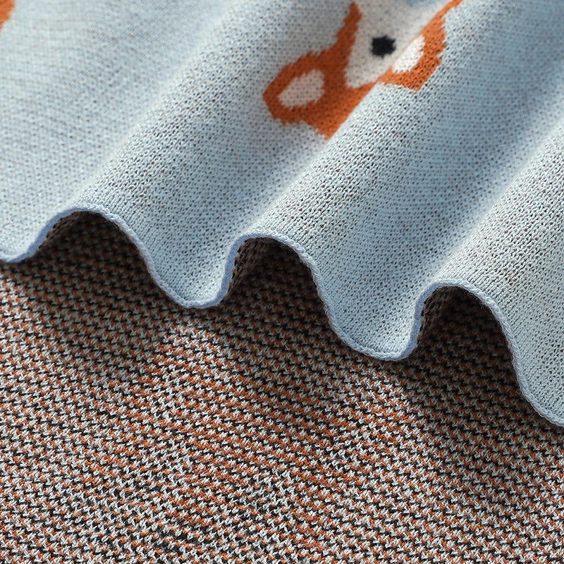 Hemmed edge detail showing front and back weave of cotton knit fox baby blanket