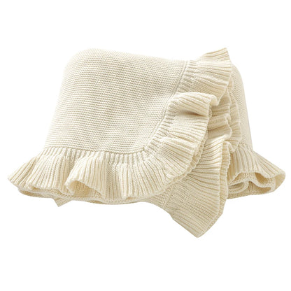 100% cotton knit baby blanket with ruffle edge in cream white folded on white background
