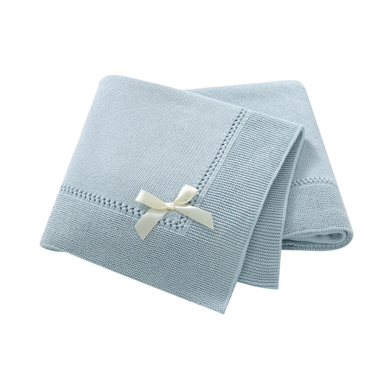 Light blue 100% cotton soft knit baby receiving blanket with bow accent folded on white background
