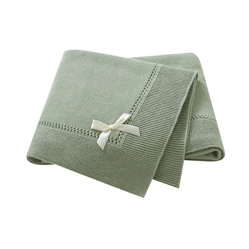Sage green 100% cotton soft knit baby receiving blanket with bow accent folded on white background