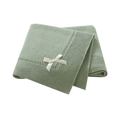 Sage green 100% cotton soft knit baby receiving blanket with bow accent folded on white background
