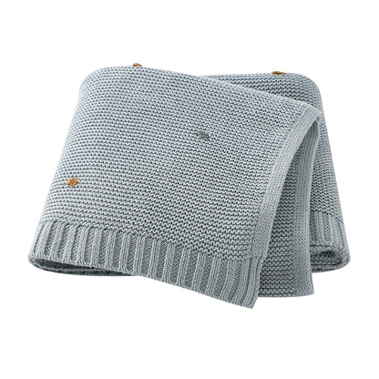 Soft 100% cotton knitted baby blanket in Cloud Blue featuring a textured popcorn dot pattern and ribbed edges.