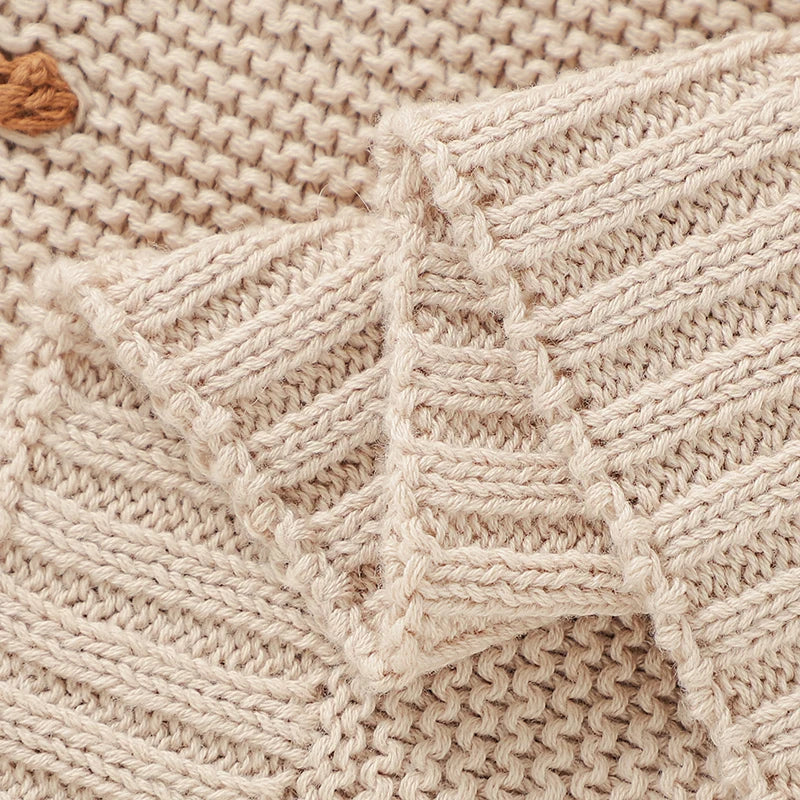 Detailed view of the neatly finished ribbed edge trim and premium knit craftsmanship on the Toasted Almond dotted baby receiving blanket.