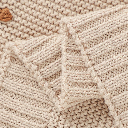 Detailed view of the neatly finished ribbed edge trim and premium knit craftsmanship on the Toasted Almond dotted baby receiving blanket.