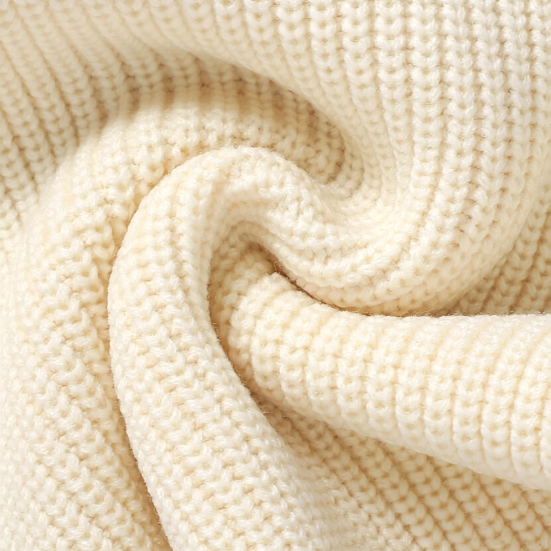 Close-up showing the soft, ribbed knit fabric texture of the baby sweater romper in cream.