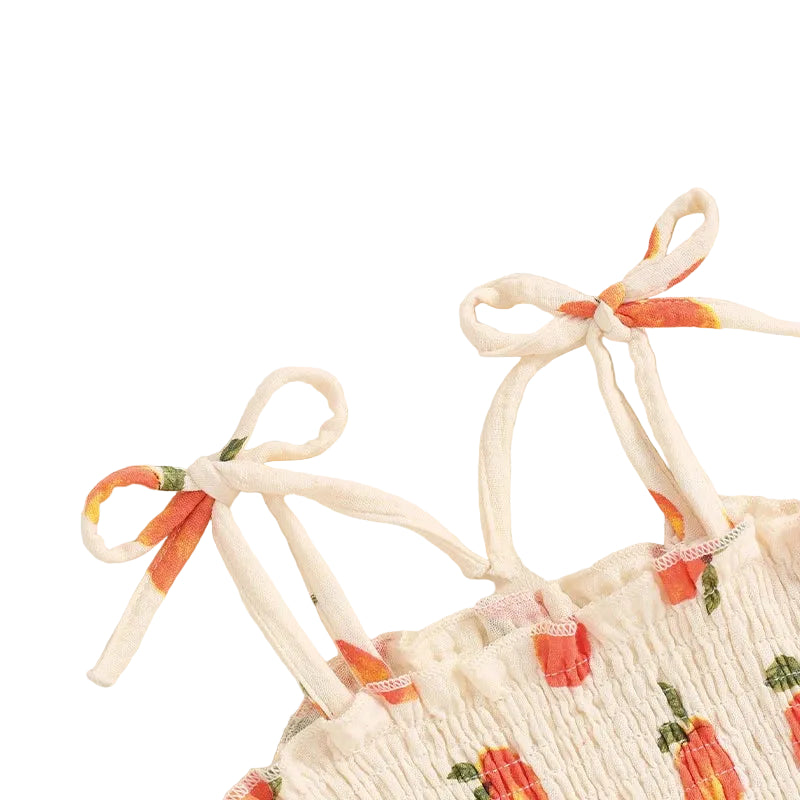 Close-up of the adjustable tie-strap shoulders on the baby girl peach print romper dress.