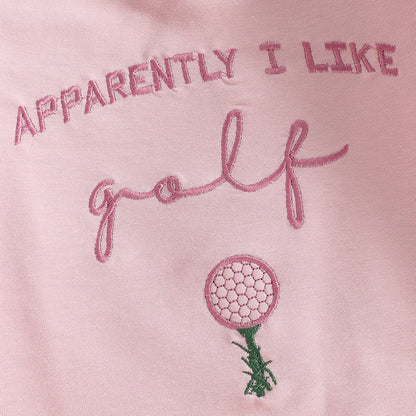 Close-up detail of the "Apparently I Like Golf" text and golf ball on a tee embroidery on the pink infant romper.