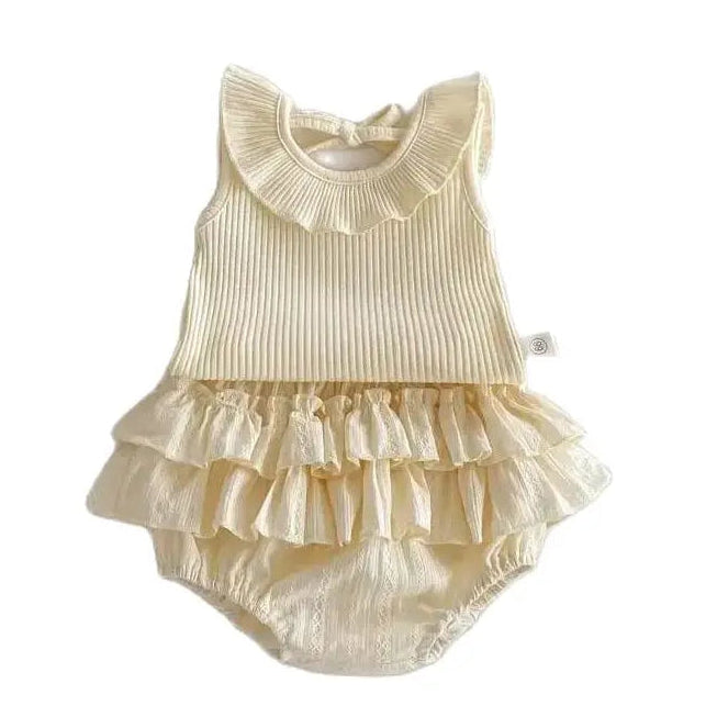 Aria boutique baby girl two-piece matching set in cream featuring a sleeveless ribbed cotton top with a pleated ruffle collar and matching triple-layered ruffle bloomers on a clean white background.