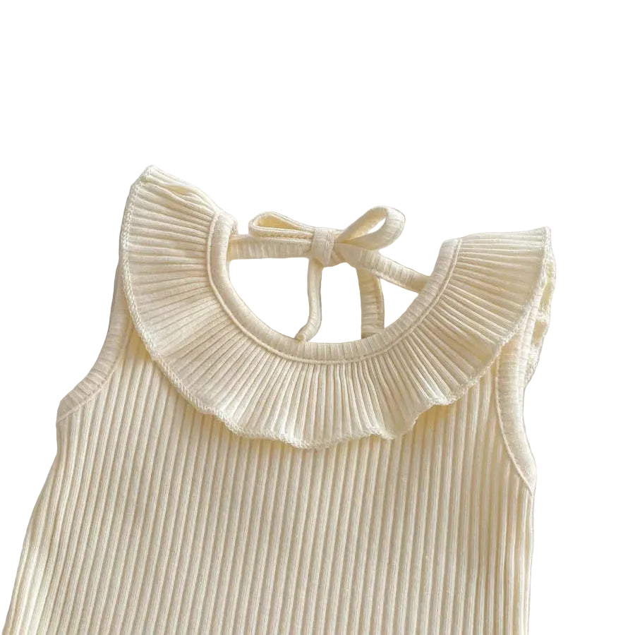 Close-up view of the cream ribbed baby top showing the delicate ribbon tie closure and pleated ruffle collar.