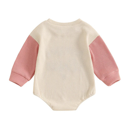 Back view of the Kidsely pink and cream colorblock baby girl waffle knit romper.