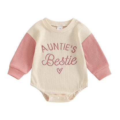 Front view of the Kidsely Auntie's Bestie baby girl long sleeve waffle knit romper in pink and cream.