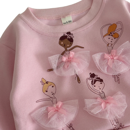 Close-up of embroidered ballerina figures with 3D pink mesh tulle skirts on toddler crewneck sweatshirt.