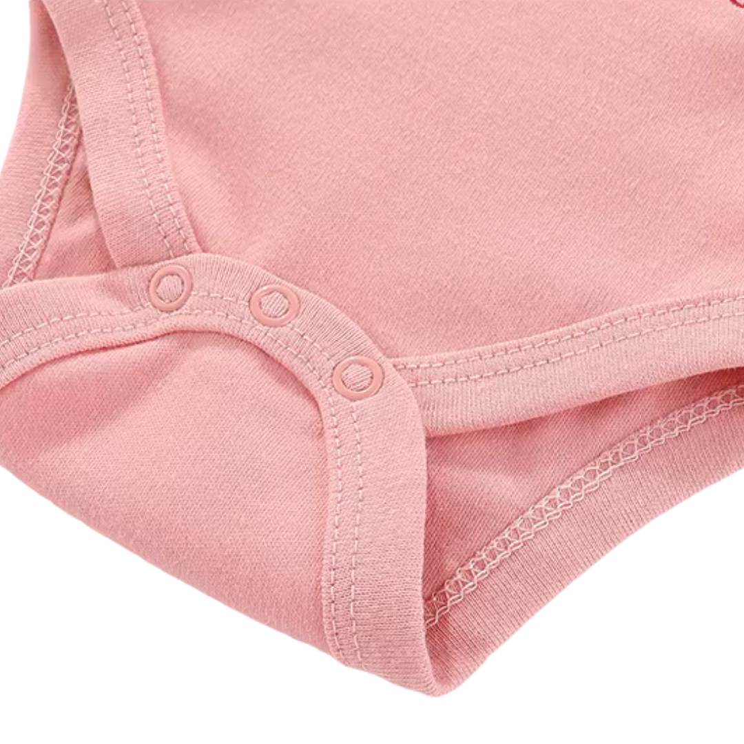 Close-up of bottom crotch snap closures on pink baby bodysuit for easy diaper changes