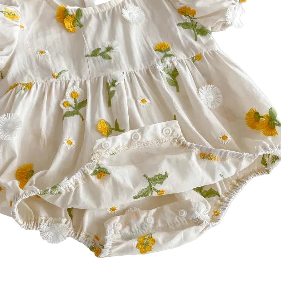 Bottom view of a baby girl romper showing the opened crotch snap closures designed for easy diaper changes.