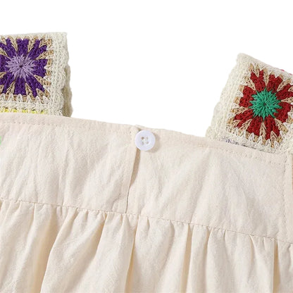 Back view close-up of the square collar showing the single white button closure on the cotton baby playsuit.