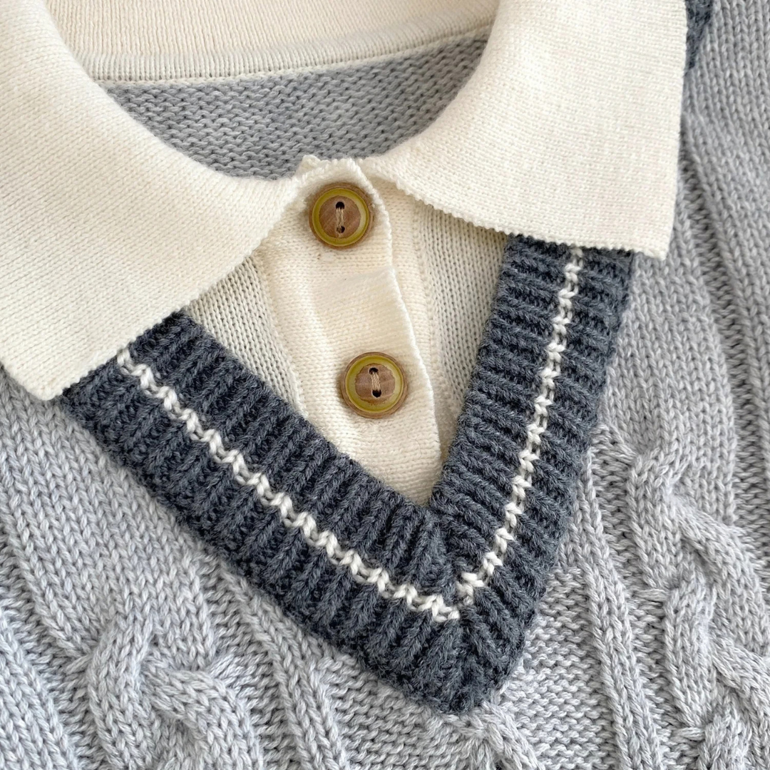 Close-up of ribbed polo collar and faux-wood buttons on baby boy cable knit sweater romper