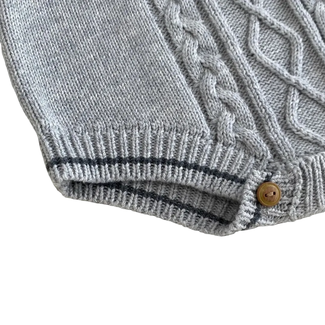 Close-up detail of ribbed cuff leg openings and bottom snap closures for easy diaper changes