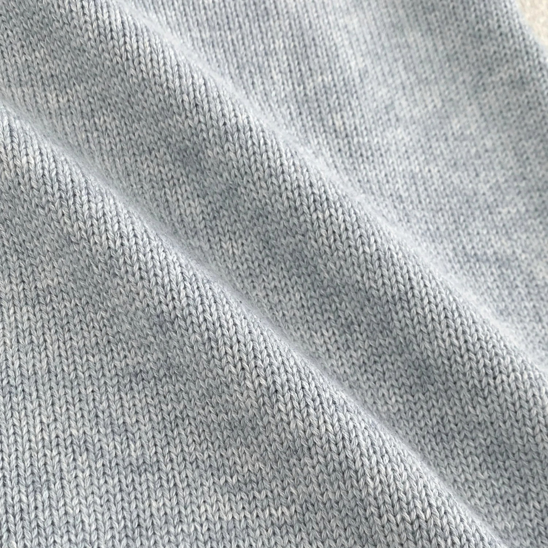 Close-up texture of soft cotton-blend cable knit fabric for baby sweater romper