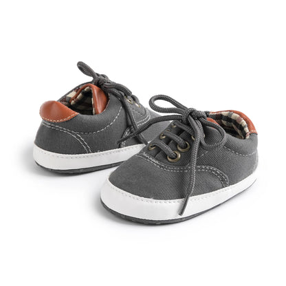 Charcoal grey toddler canvas shoes with flexible pre-walker soles and secure lace-up closure.