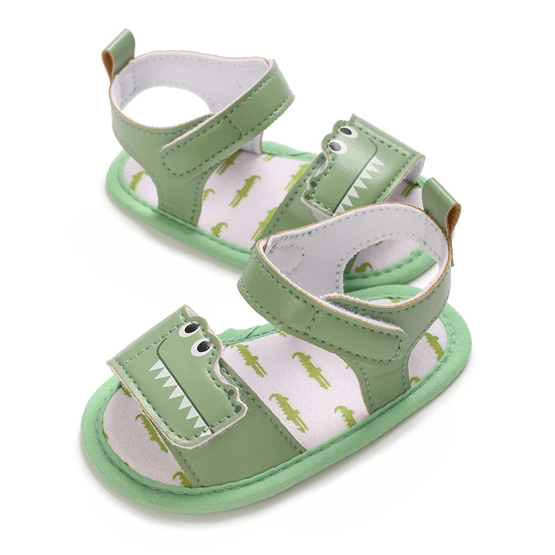 Side view of green infant alligator sandals highlighting the secure hook and loop ankle strap.