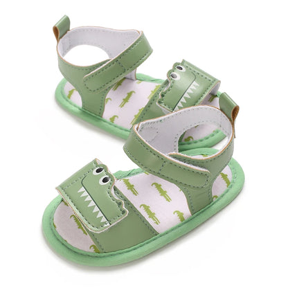 Side view of green infant alligator sandals highlighting the secure hook and loop ankle strap.