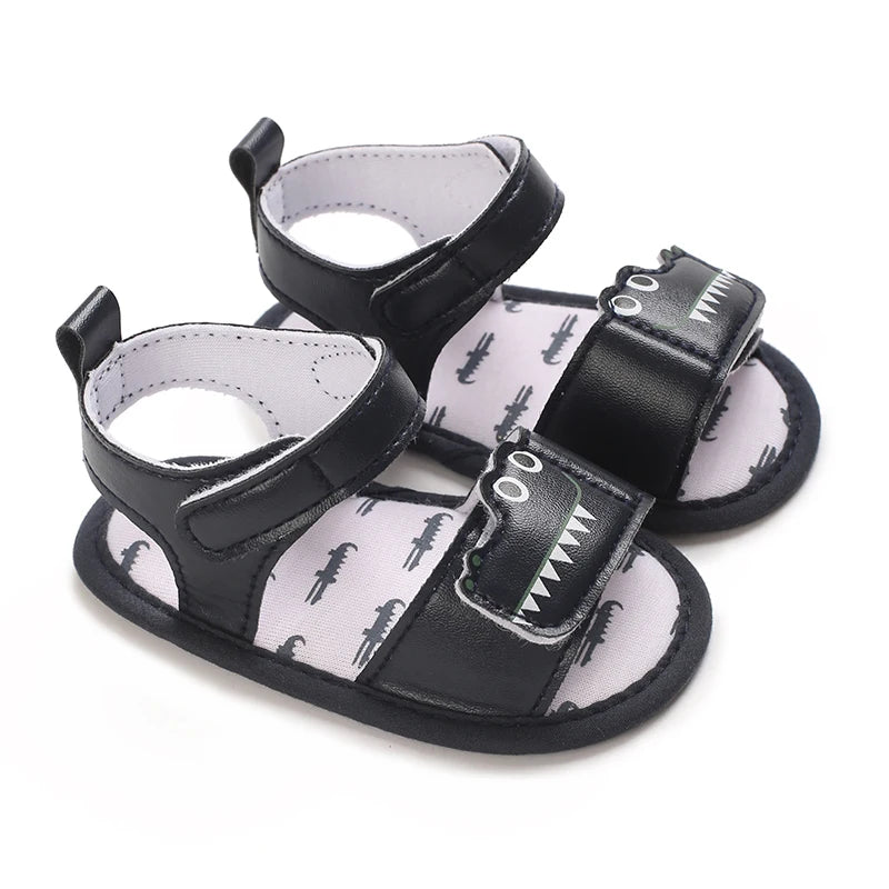 Pair of navy blue baby boy alligator sandals with a layered cutout gator face design.