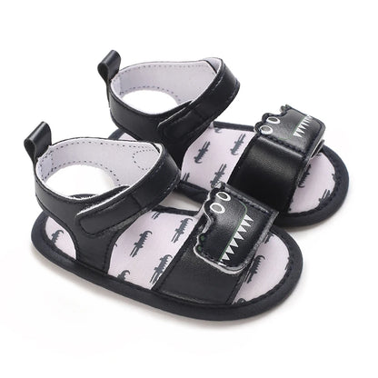 Pair of navy blue baby boy alligator sandals with a layered cutout gator face design.