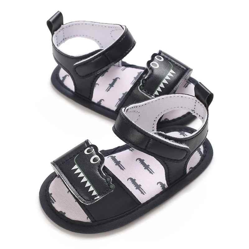Side angled view of navy blue infant first walker sandals featuring a crocodile design and adjustable strap.