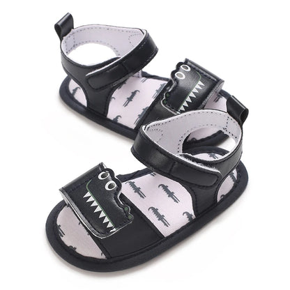 Side angled view of navy blue infant first walker sandals featuring a crocodile design and adjustable strap.