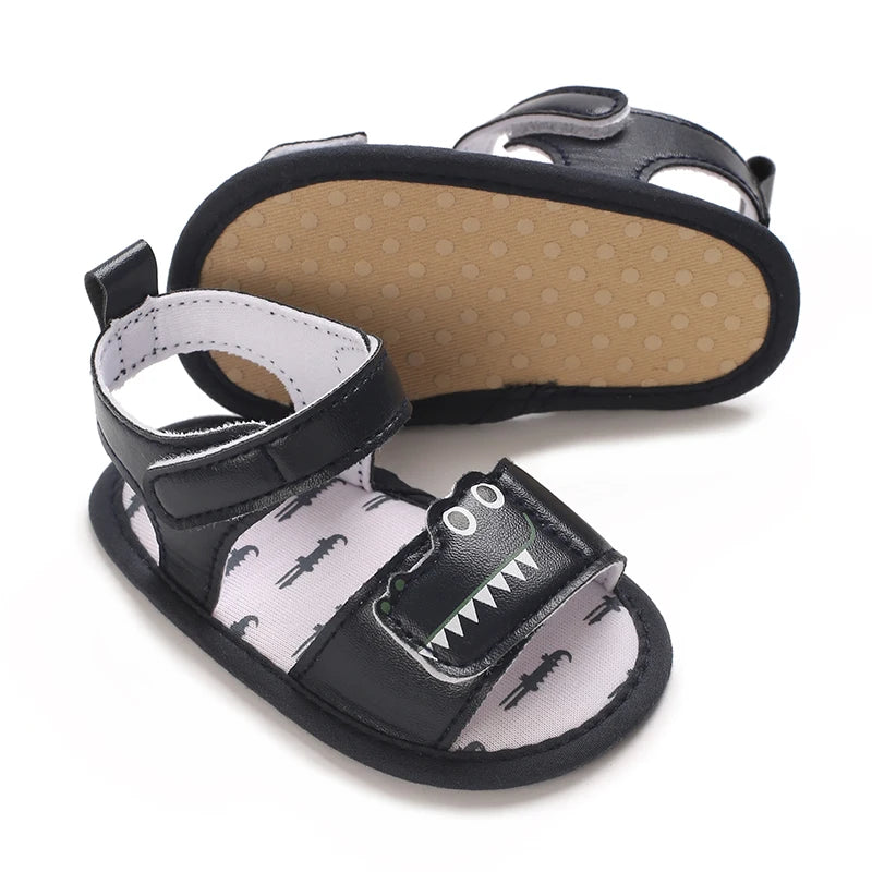 Navy blue infant crocodile sandals showing the soft, flexible cotton bottom with grip dots.