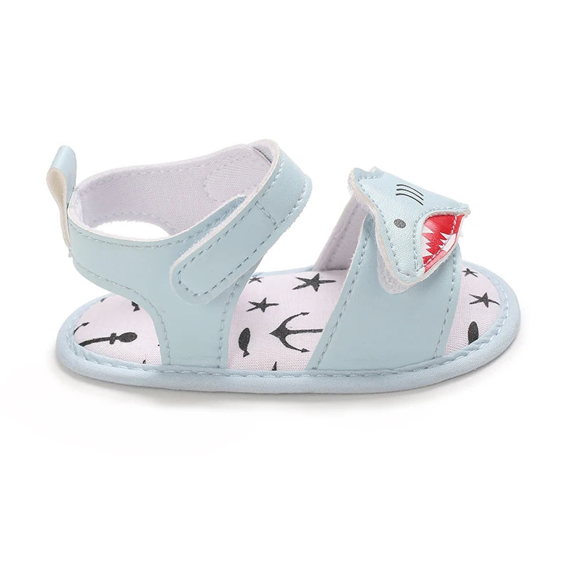 Side profile of a light blue baby shark sandal showing the adjustable hook and loop ankle strap.