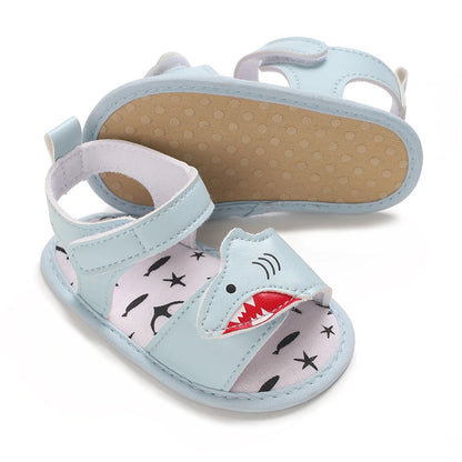 Light blue infant shark sandals showing the flexible soft cotton bottom sole with anti-slip grip dots.