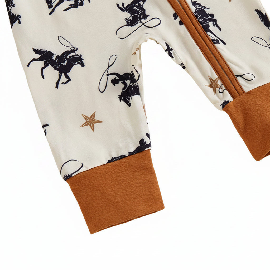 Close-up of the contrasting brown ankle cuffs on the bottom legs of the baby boy western cowboy print romper.
