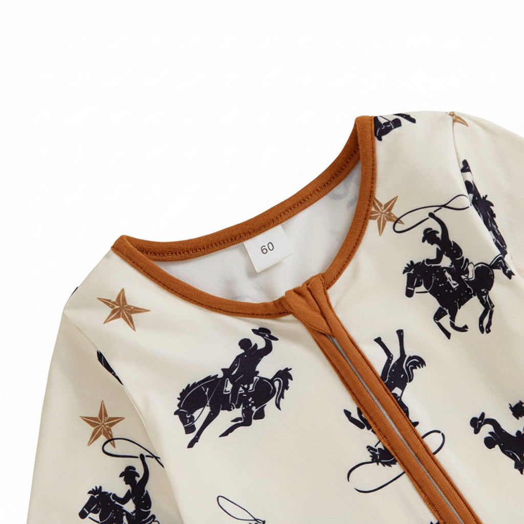 Close-up of the round neckline and closed diagonal zipper with a protective fabric zipper guard on the western cowboy print baby romper.