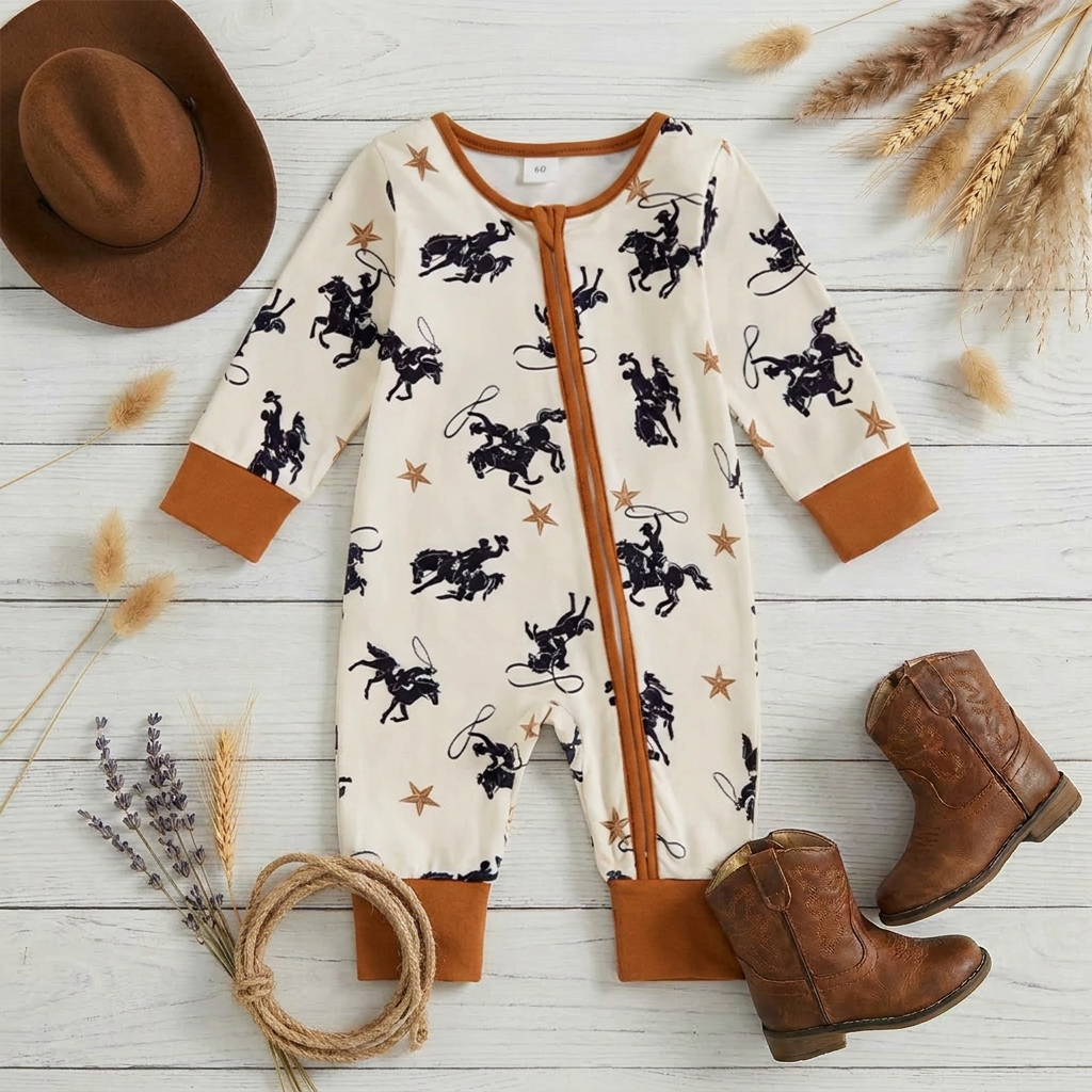 Flat lay of the baby boy western cowboy print romper on a rustic wooden surface, styled with a small cowboy hat, leather baby boots, and a decorative rope lasso.