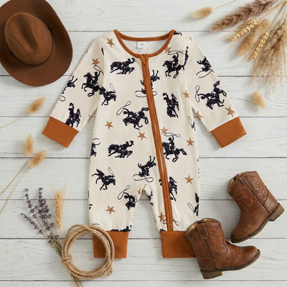 Flat lay of the baby boy western cowboy print romper on a rustic wooden surface, styled with a small cowboy hat, leather baby boots, and a decorative rope lasso.