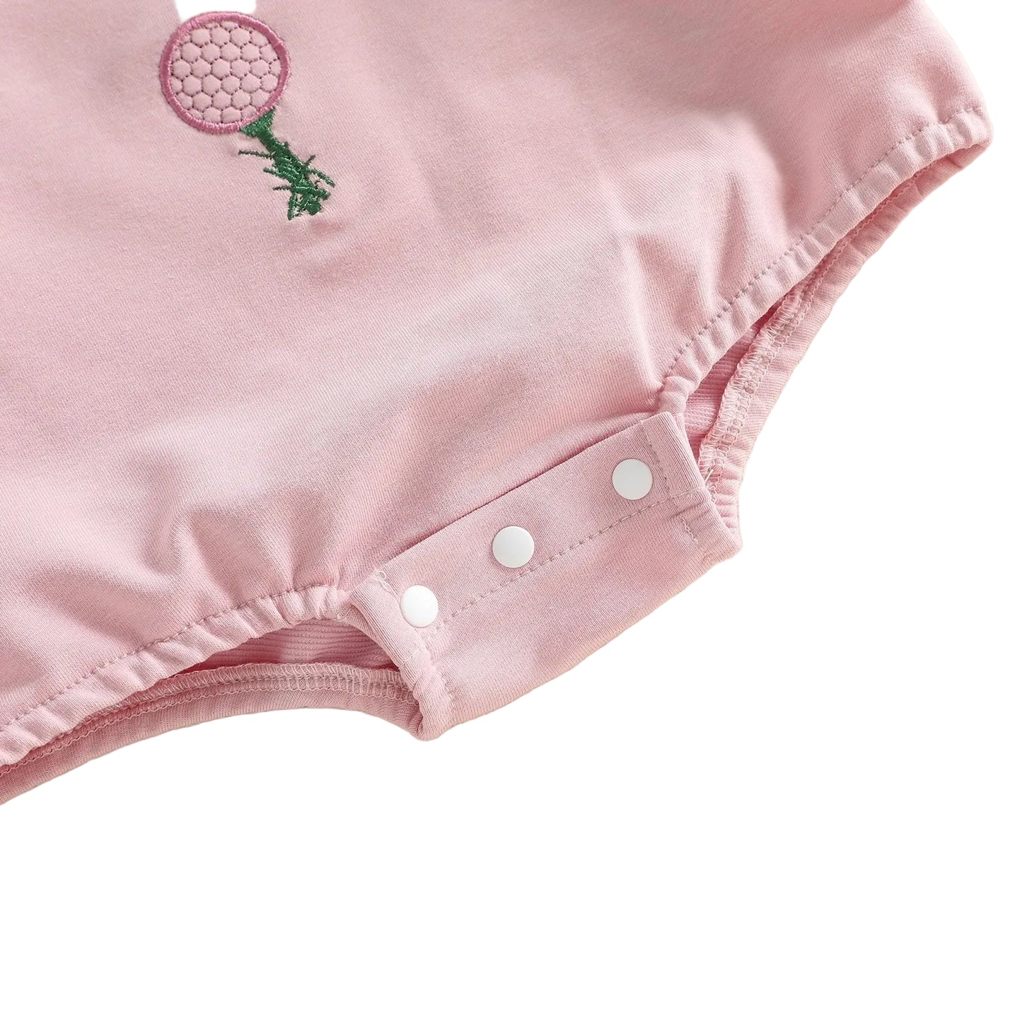 Close-up of the convenient bottom snap closures and gathered bubble-style leg openings on the pink baby romper.