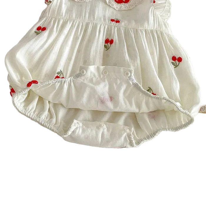 Detailed view of the open snap bottom on a baby girl cotton muslin bubble romper showing interior lining and construction.