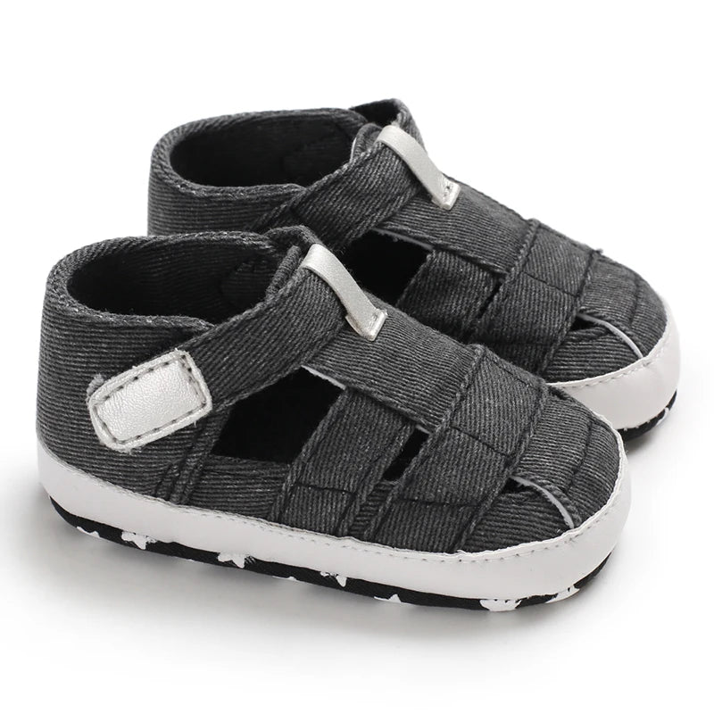 A pair of breathable dark gray black baby canvas summer sandals on a white background.