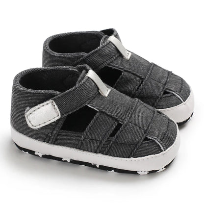 A pair of breathable dark gray black baby canvas summer sandals on a white background.