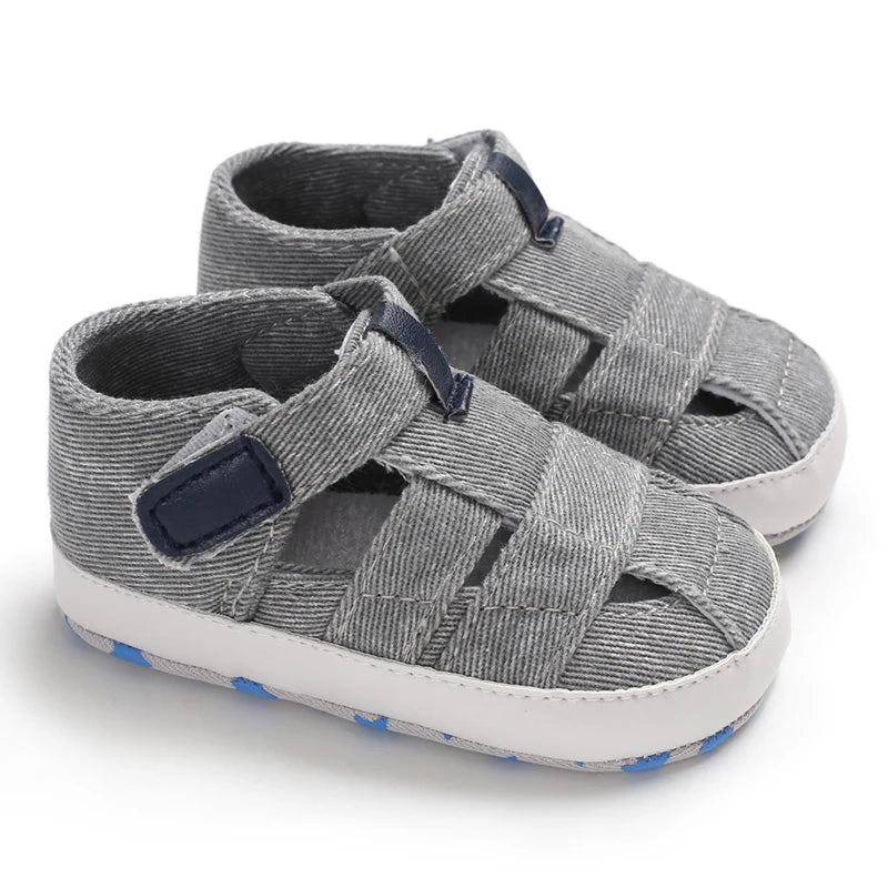 A pair of breathable light gray baby canvas summer sandals with navy blue accents on a white background.