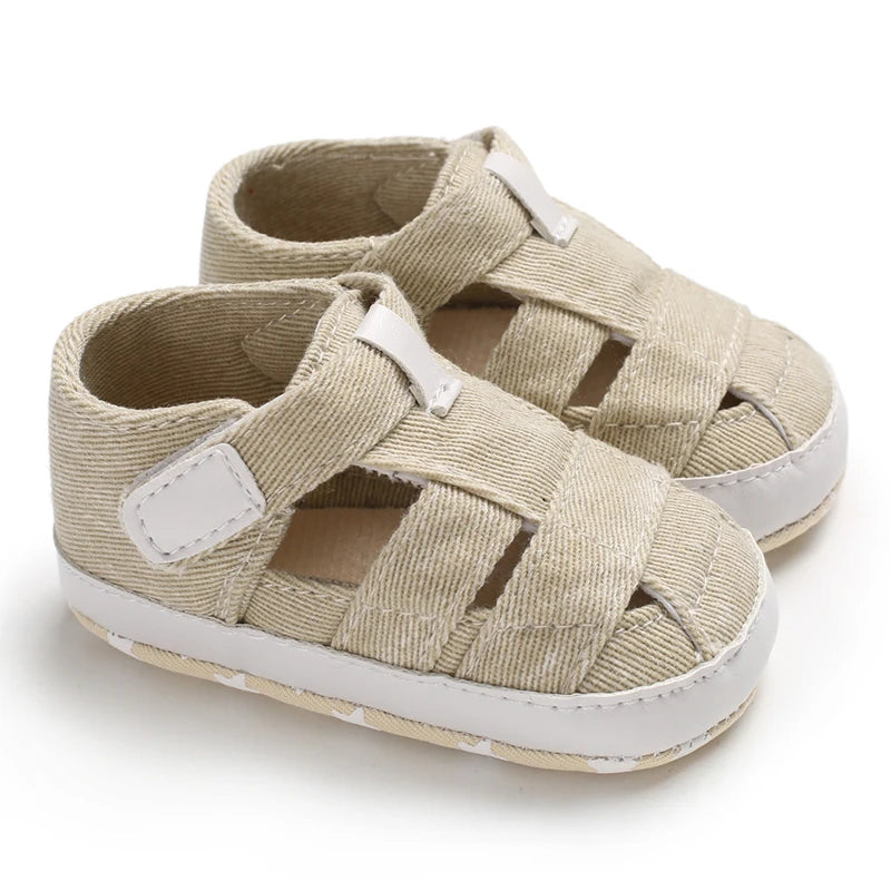 A pair of breathable tan beige baby canvas summer sandals on a white background.
