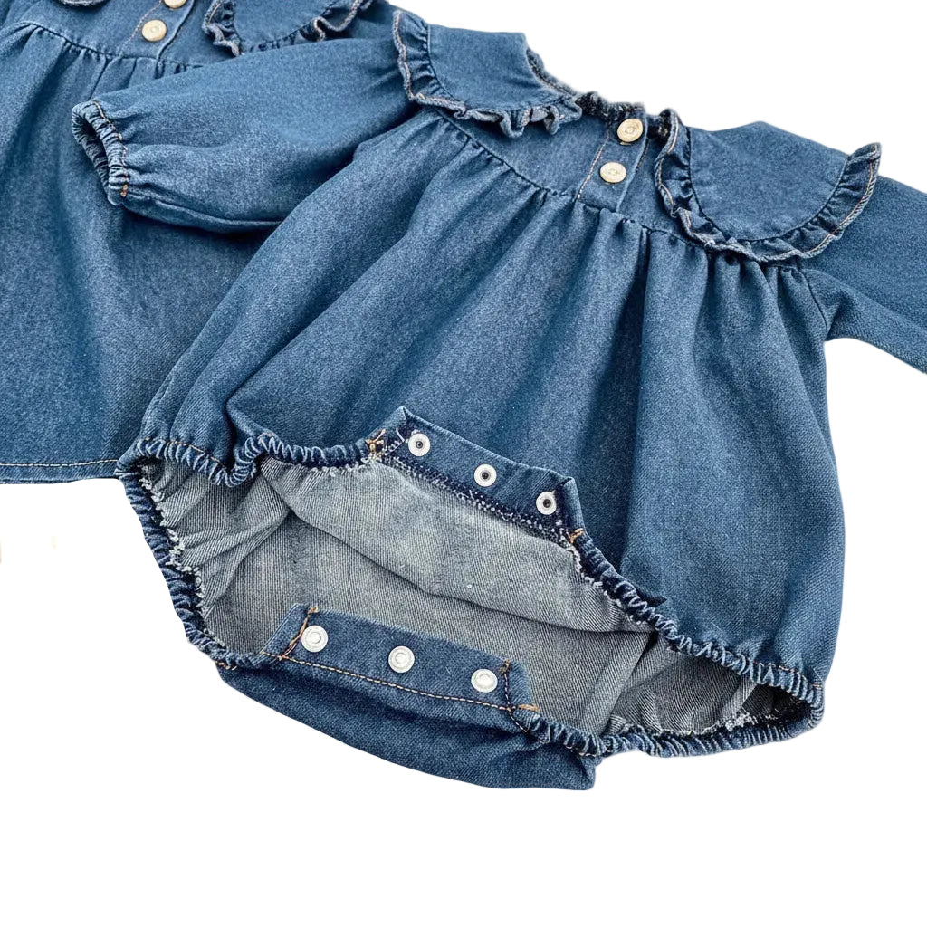 Close-up showing the convenient bottom snap closures on the baby girl blue denim bodysuit for easy diaper changes.