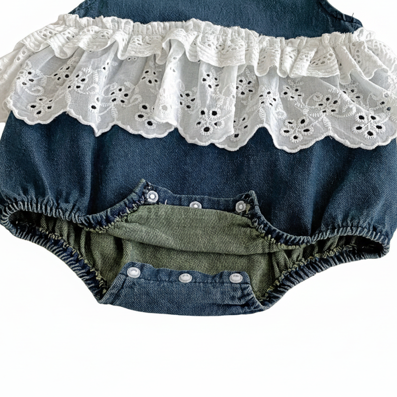 Interior view of the open snap crotch closure on a baby girl denim romper, highlighting easy diaper access.