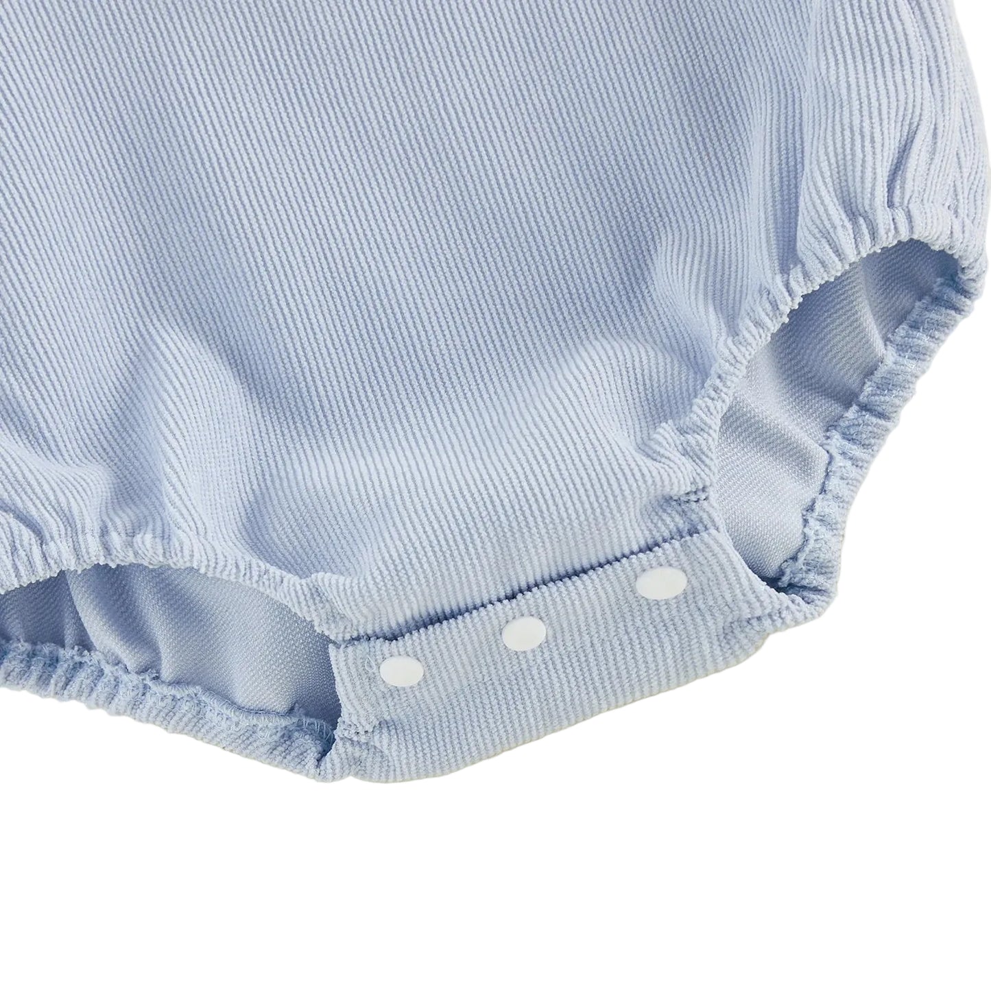 Close-up view of the gathered elastic leg openings and three white plastic bottom snap closures on an infant bubble romper.