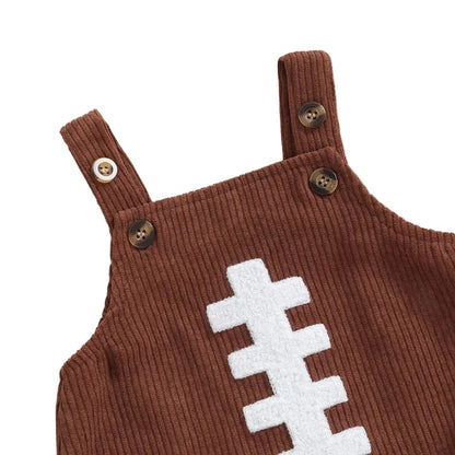 Close-up of shoulder button straps and football lace embroidery on brown corduroy baby romper