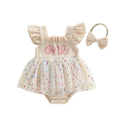 Cream baby girl 1st birthday confetti tutu romper with matching elastic bow headband.